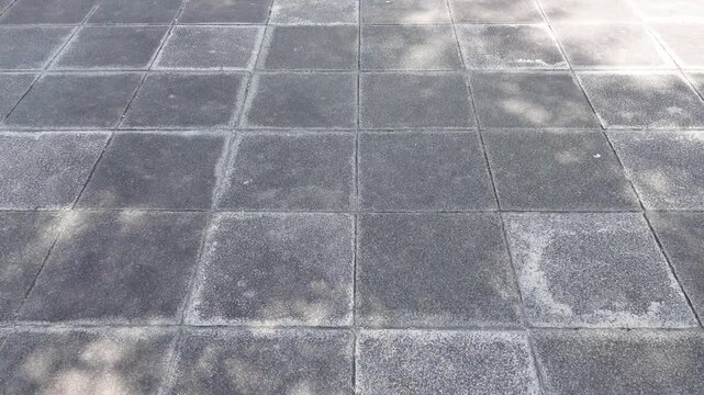 Dappled shade pattern on stone pavement summer light and shadow