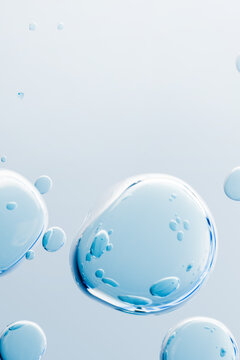 Floating blue transparent bubbles with liquid texture on a clean light background. Vertical 3D render for skincare serum, hydration, cosmetic science and biotechnology concept.	