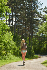 Fototapeta premium Thinking, calm or woman in nature with sightseeing, trip mindset or mindfulness on summer break. Back, fresh air or person in forest with walk, reflection or peaceful perspective in outdoor getaway.