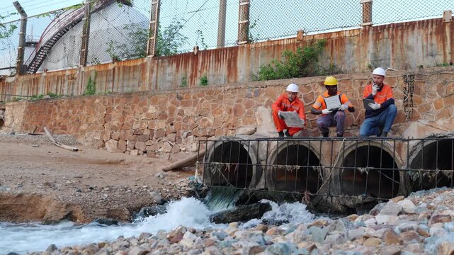 Construction workers inspecting water drainage system urban site photo series industrial environment ground level engineering insights