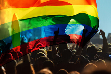 pride community at a parade with hands raised and the LGBT flag - symbol of love and tolerance © Melinda Nagy