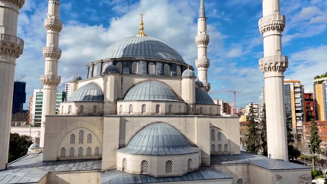 Circular aerial view orbiting the large central dome and towering minarets of the Namazgah Mosque in Tirana, Albania, showcasing its intricate Ottoman architecture