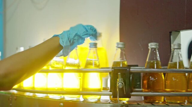 Bottling process of beverage production factory industrial action controlled environment close-up view quality control