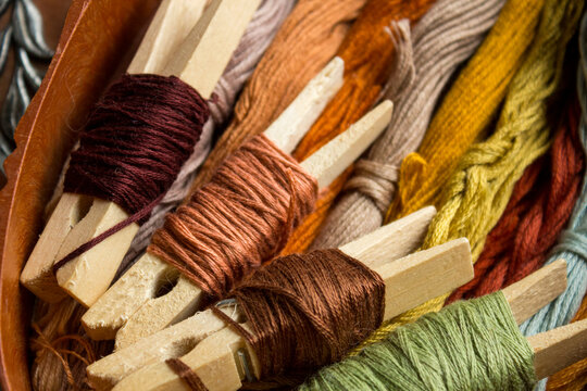 Close up of brown embroidery threads arranged in a craft box. Cozy handmade atmosphere with warm neutral tones. Perfect for needlework, sewing, embroidery and hobby workspace concepts.