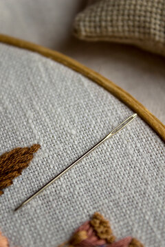 Extreme close-up photo of a sewing and embroidery needle showing fine metallic texture and precision. Ideal for tailoring, textile craft, hand sewing, DIY and fashion production concepts.