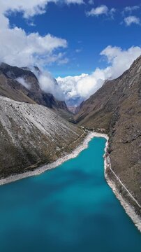 Huaraz, Peru: Footage of famous laguna paron in Caraz, Huaraz region, Peru. Surrounded by mountain range and with cloudy dramatic sky, showing cordillera blanca in the background. Taken with forward a