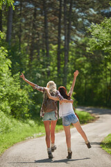 Fototapeta premium Travel, hugging or friends in nature with fun, good time and bonding trip on summer break. Back, sunshine or women in forest with walk, vacation connection or playful embrace in outdoor getaway.