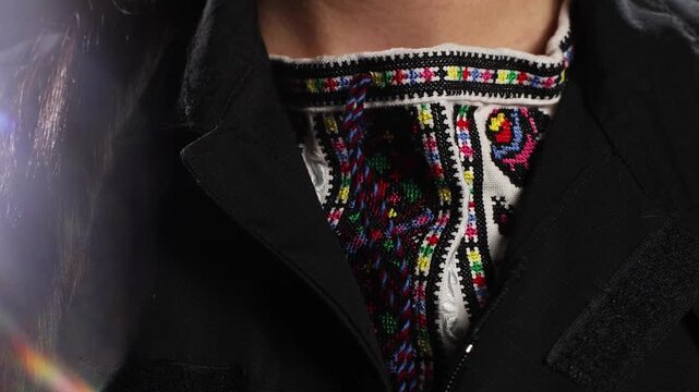 Close-up of police officer buttoning traditional Ukrainian embroidered vyshyvanka shirt under uniform jacket. Powerful symbol of national identity, cultural pride and civic duty.