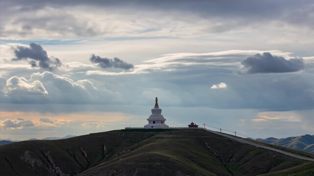 White Buddhist Stupa on Hilltop Under Dramatic Cloudy Sky