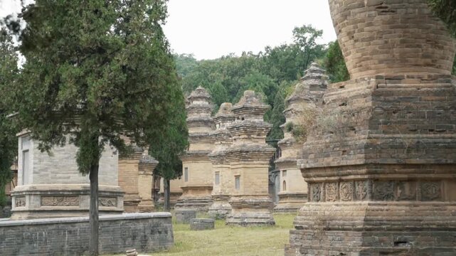 Pagoda Forest at Shaolin Temple in China, Asia, showing ancient stone pagodas surrounded by green mountains and forest landscape in serene atmosphere