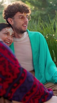 Festival, relax and nature with happy couple with group for social gathering, bonding or retro event. Man, woman or laughing with community, chat or discussion for outdoor concert or vintage music