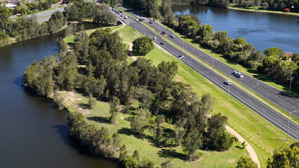 Fototapeta premium Aerial View of Lakeside Roadway and Green Parkland in Gold Coast Australia