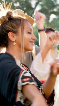 Friends, dancing and happy at music festival in summer with drinks, outdoor and excited at party. People, group and spring break with alcohol, concert or rhythm with celebration on getaway in nature