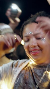 Outdoor, dance and woman with lights for festival, fun and listening to music entertainment at night. Dark, event and people with smile for celebration, bokeh and social gathering for festive season