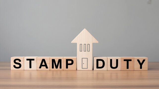 A house model and wooden blocks with 'STAMP DUTY' on a table