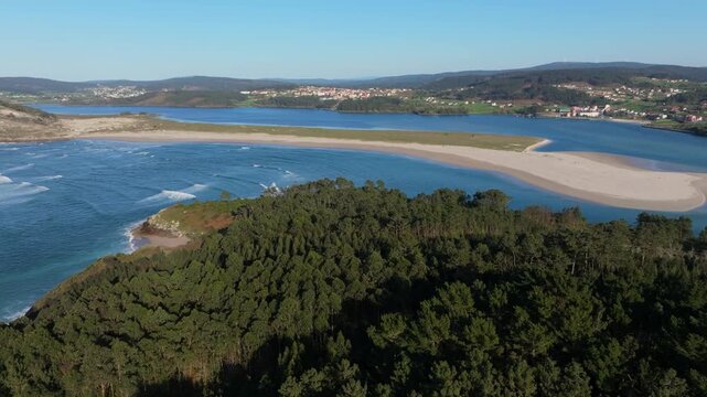 Coastal Estuary Landscape With Dense Forest In Foreground And Sandy Beach In Galicia, Spain. wide aerial shot