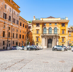Obraz premium Sunny daytime view of an urban square in Rome, Italy, featuring old yellow orange palace facades, an architectural arch bridge street. Italian summer.