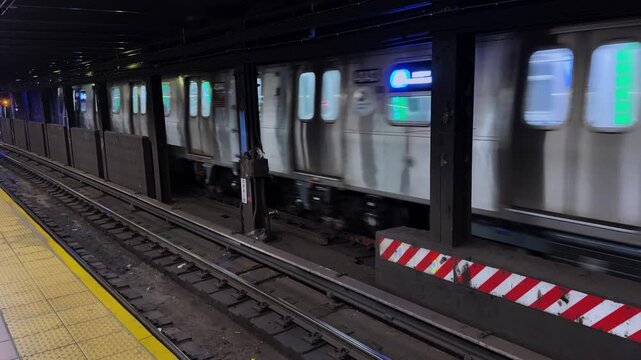 Rat scurries along subway track as train passes through underground station platform
