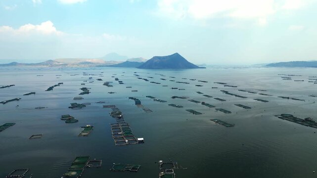 Wide establishing aerial of Berinayan fish pond area near Taal Lake and volcanic landscape.