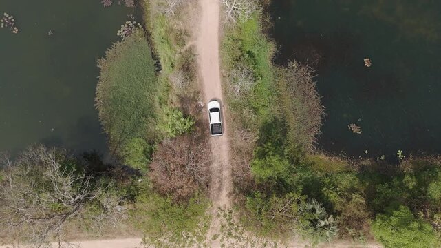 Aerial view of scenic landscape of driving pickup road in a deserted area through a tropical forest
