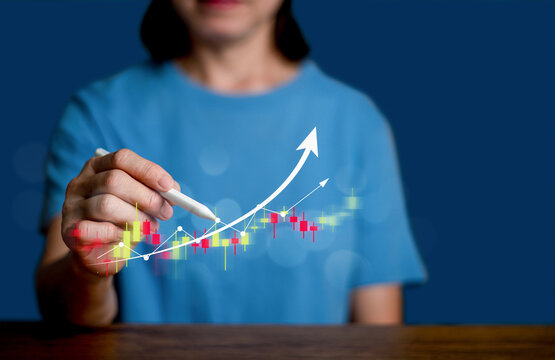 Woman drawing rising financial graph with glowing stock market chart and upward arrow, symbolizing business growth, investment success, trading, and financial technology.