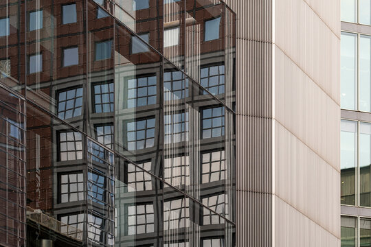 Urban architecture shows glass reflection across a corporate building facade, where abstract geometry and windows overlap pale cladding and city lines