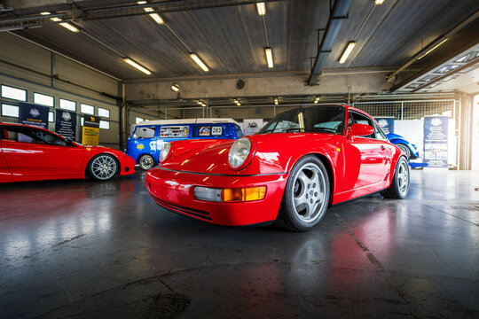 Brno, Czech Republic - May 14, 2026: Classic sports car Porsche 911 (generation 964) Carrera 2 from 1992 in red color stands in a garage.