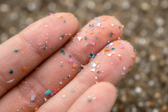 Close up side shot of microplastics lay on people hand. Concept of water pollution and global warming. Climate change idea. micro plastics concept in food and water or sea