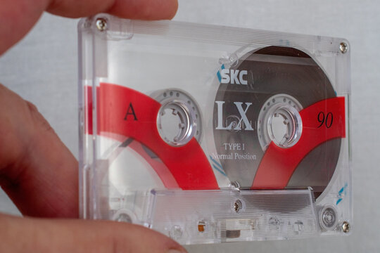 Kyiv, Ukraine, May 21, 2026: Hand holding a classic skc lx 90 audio cassette tape with transparent shell, bringing back retro music memories.