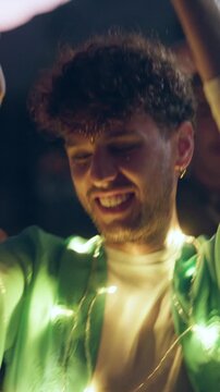 Man, night and dancing at music festival with smile for fun, celebration and energy at live concert. Happy, person and lights at groove event, freedom and moving with rhythm at outdoor rave party