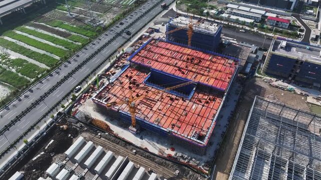 Aerial view of high-rise residential building construction site with cranes and framework