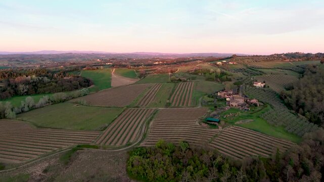 Widok z drona na pola uprawne w Toskanii, Włochy. Zach&oacute;d słońca, golden hour. Agroturystyka.