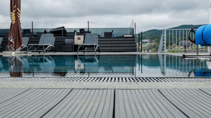 Fototapeta premium Luxury rooftop infinity pool with mountain views on a cloudy day