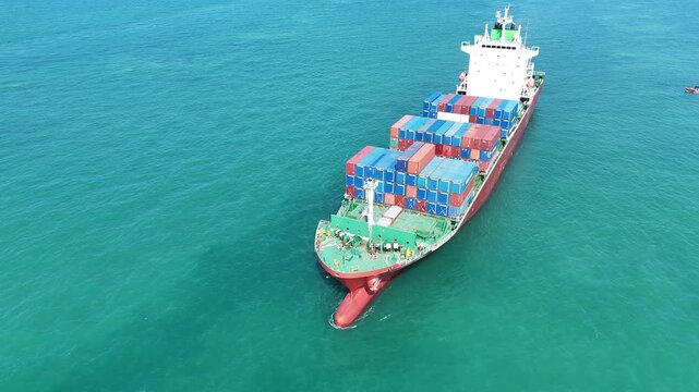 cargo container ship fully loaded with pink and red containers, assisted by a tugboat in the turquoise ocean. Global maritime logistics and supply chain concept.	international trade, and heavy ship