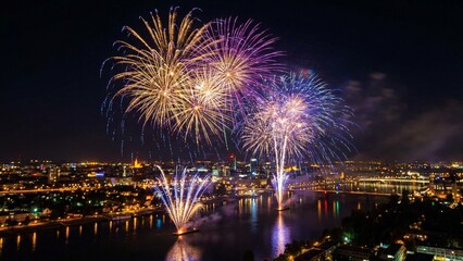Fototapeta premium Spectacular Fireworks Display Over the City Skyline and River at Night