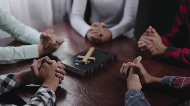 Group of Christian  praying worship together to believe and Bible on a wooden table for devotional for prayer meeting concept, teamwork. Christian worship and pray.