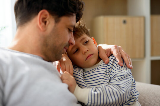 Father comforting son during difficult moment at home
