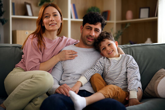 Happy family portrait sitting together on sofa at home