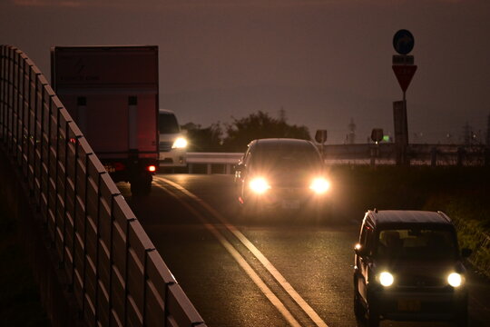ヘッドライトを点灯して走る夜の車