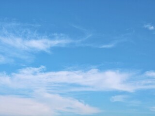 Fototapeta premium A serene and beautiful bright blue sky filled with soft, wispy white clouds during a clear day, perfect for nature and background concepts