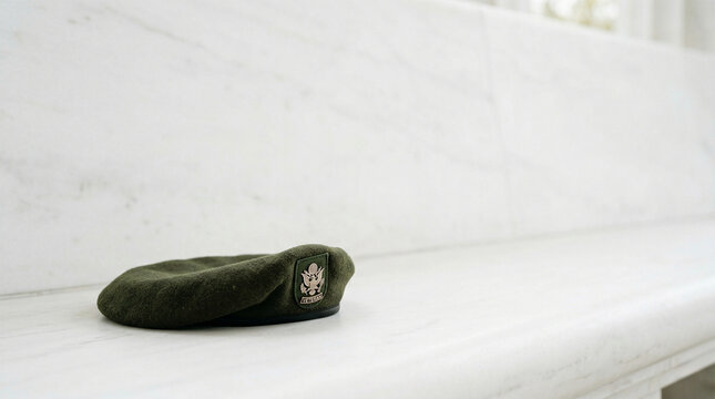 US Army Green Beret with Veteran Emblem Resting on White Marble Surface