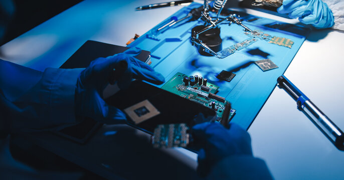 Hands in white gloves carefully repair a broken mobile device, meticulously working on the intricate internal electronics and circuit board