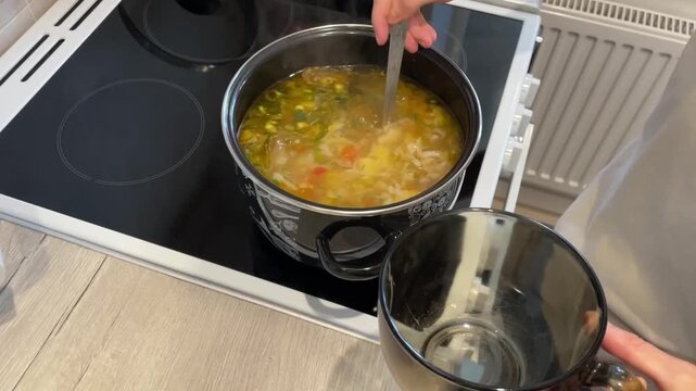ladling steaming vegetable soup from pot into bowl, closeup of ladle scooping colorful broth with vegetables, stovetop scene showing simmer and steam, comforting home meal serving