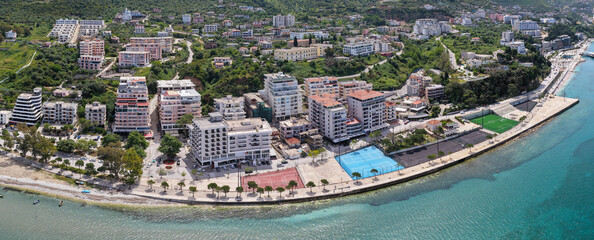 Aerial image over the vibrant coastline of Vlora, Albania, showcasing the multi-sport outdoor athletic courts along the seaside promenade.  © bardhok