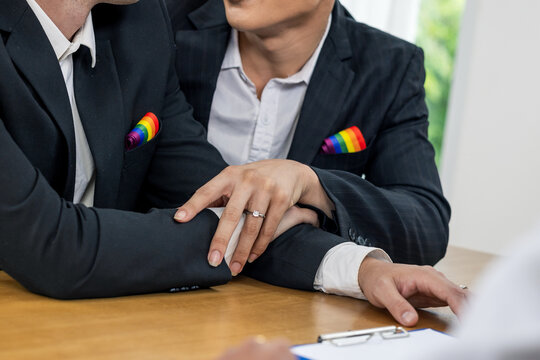 Legal status of same-sex marriage, LGBT human rights, equality and freedom concept. Two gay with diamonds ring prepare to sign in marriage paper for marriage certificate.