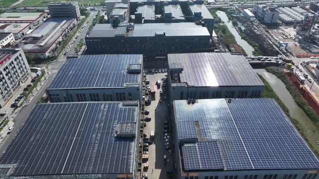 Aerial view of industrial factory rooftops covered with solar photovoltaic power generation panels