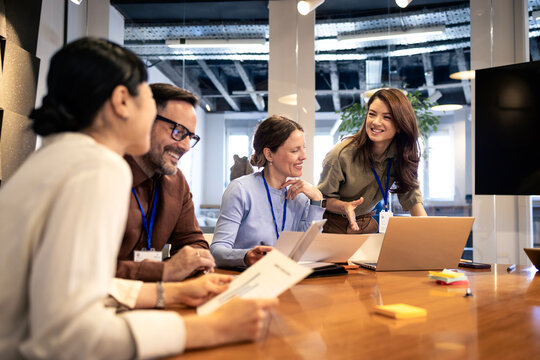 Business team collaborating around a table, discussing strategy and sharing ideas in a modern office meeting