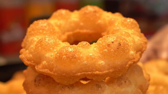 Delicious stack of golden fried dough fritters. Close-up macro view of crispy and bubbly textured sweet pastries.