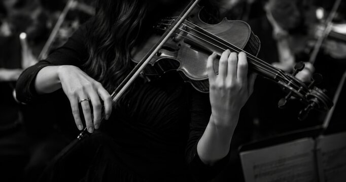 Elegant violinist performing classical music in monochrome concert atmosphere with cinematic lighting, detailed violin strings and emotional orchestral performance
