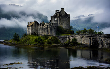 Naklejka premium Medieval castle in Scotland surrounded by misty hills, mysterious mood, ultra detailed fantasy-like travel photography.